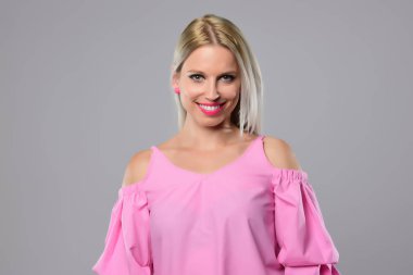 Genç kadın stüdyo ışık arka plan üzerinde poz