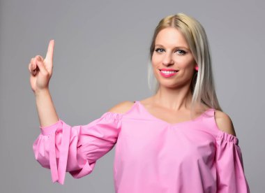 Genç kadın stüdyo ışık arka plan üzerinde poz