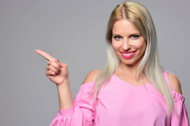 Genç kadın stüdyo ışık arka plan üzerinde poz