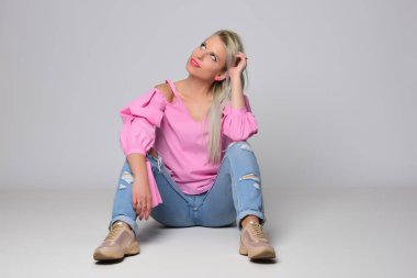 Genç kadın stüdyo ışık arka plan üzerinde poz