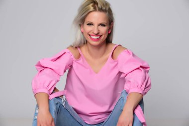 Genç kadın stüdyo ışık arka plan üzerinde poz