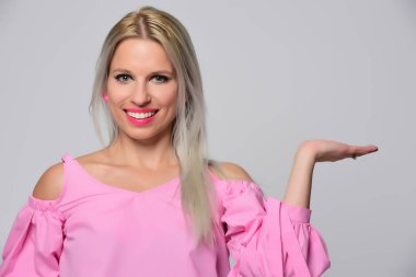 Genç kadın stüdyo ışık arka plan üzerinde poz