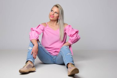 Genç kadın stüdyo ışık arka plan üzerinde poz