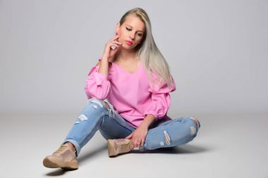 Genç kadın stüdyo ışık arka plan üzerinde poz