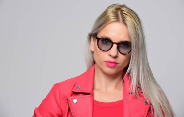 Stüdyo ışık arka plan üzerinde poz parlak deri ceketli genç kadın