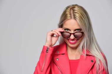 Stüdyo ışık arka plan üzerinde poz parlak deri ceketli genç kadın