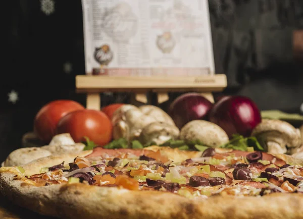 Jambon, zeytin ve domates taze pişmiş pizza. Seçici odak