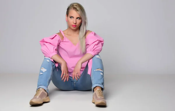 Young woman posing in studio on light background