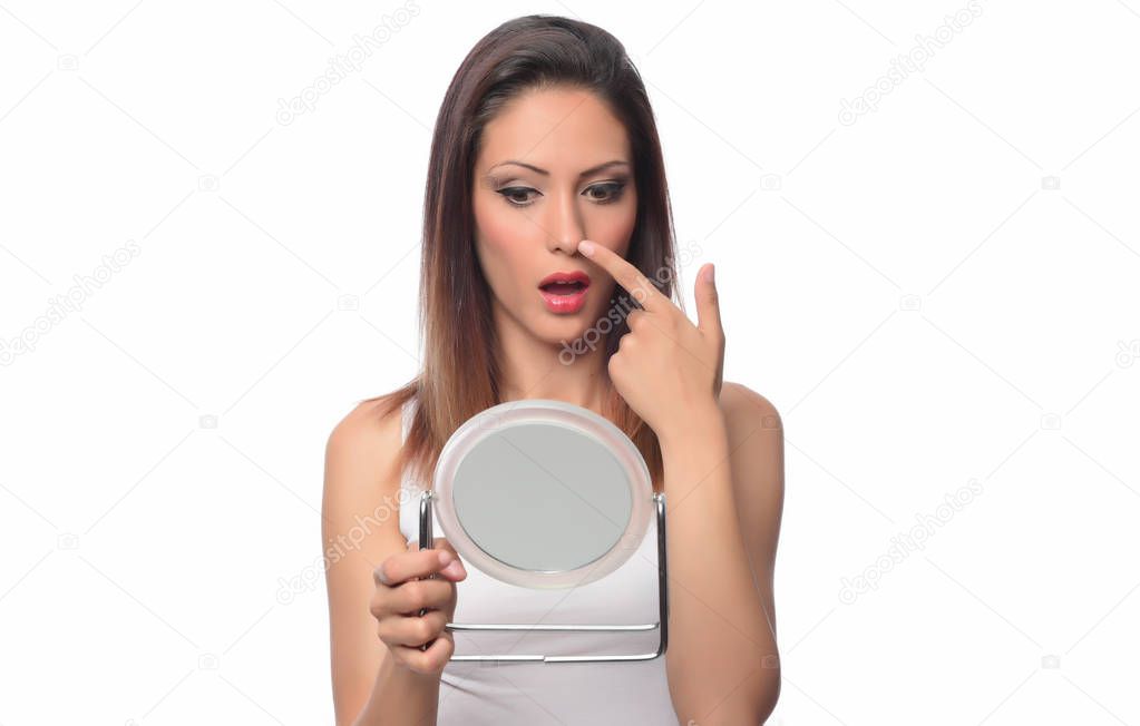 young woman checking her face in the mirror