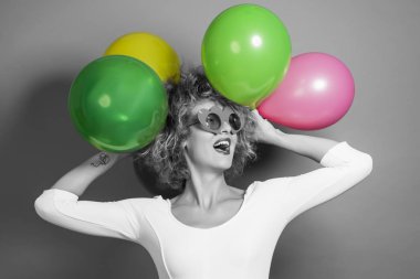 Kafasında balonlarla güzel genç bir kadın.