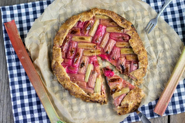 Yukarıdan gelen şekerleme küreğine dilimlenmiş rustik rubarb galette keki.