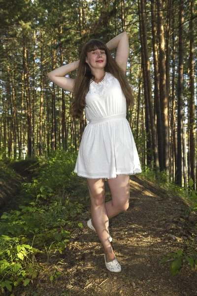 long hairy women posture in  coniferous  forest