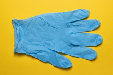 Mavi lastik tıbbi eldiven turuncu arka planda yakın plan