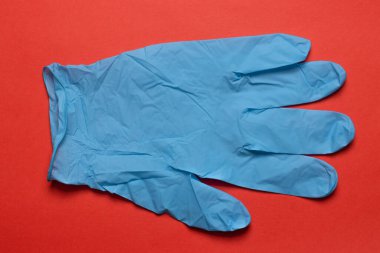 Yeşil arka planda kırmızı lastik tıbbi eldiven yakın plan