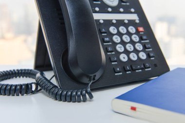 IP telefon ve mavi defter beyaz masada - teknoloji iletişim