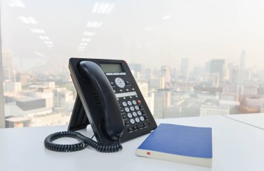IP telefon ve mavi defter beyaz masada - teknoloji iletişim