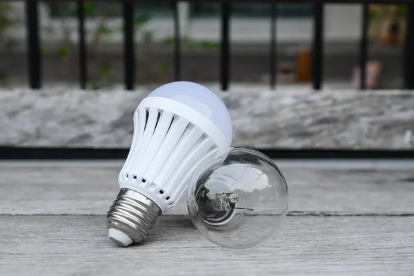 LED-Lampen und Glühbirnen auf dem Holzboden - Energieauswahl — Stockfoto