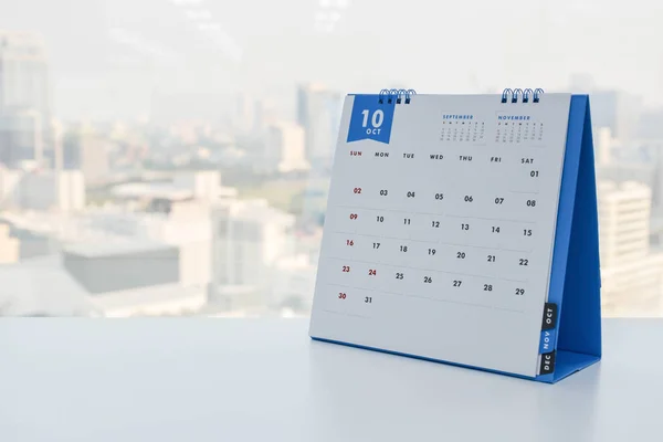 Kalendář říjen na desku bílé město na pozadí — Stock fotografie