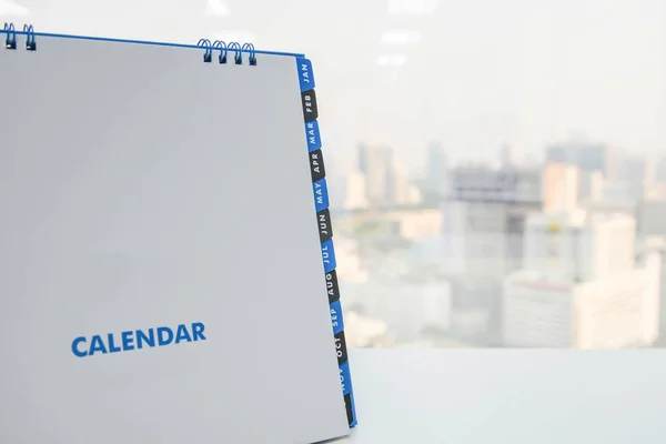 Calendario en la mesa blanca con vista a la ciudad de fondo —  Fotos de Stock