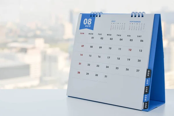 Κοντινό πλάνο - ημερολόγιο Αυγούστου στο λευκό τραπέζι με φόντο θέα πόλη — Φωτογραφία Αρχείου