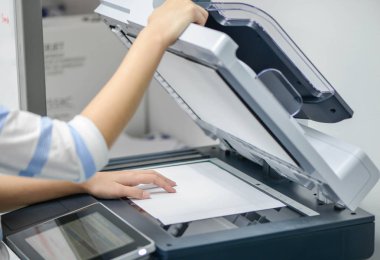 Business woman is using the printer to scanning and printing clipart