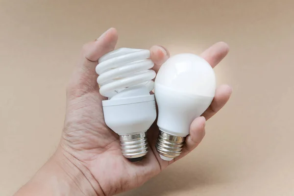 LED izzó- és kompakt fluoreszkáló villanykörte a kéz - az alternatív technológiák — Stock Fotó