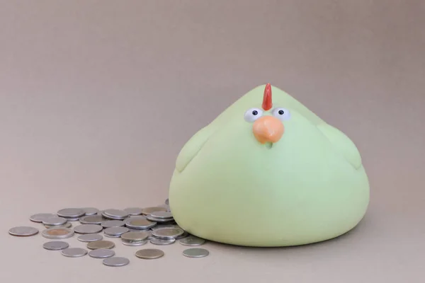 Chicken piggy bank and a lot of coins - money saving