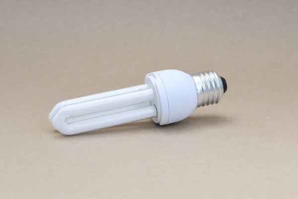 Lámpara fluorescente compacta sobre fondo marrón — Foto de Stock