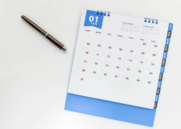 Sobre a colocação de Calendário de janeiro e caneta no fundo branco — Fotografia de Stock