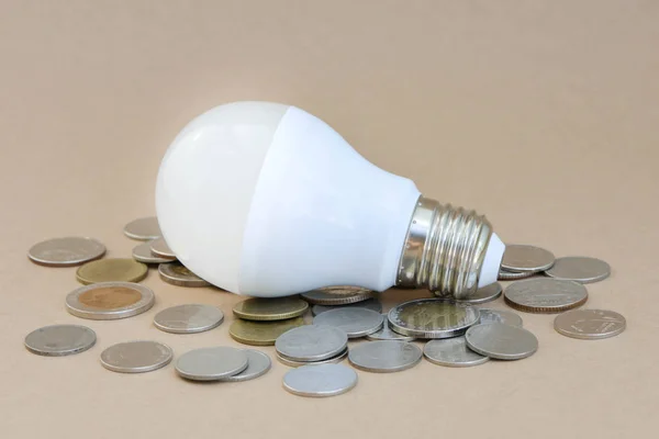 Concept of LED bulb with coins - the choice of saving technology — Stock Photo, Image