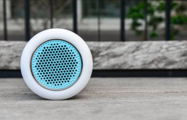 Ahşap masa üzerinde beyaz kablosuz hoparlör