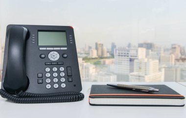IP telefon ve defter kalem beyaz ofis masasında ile