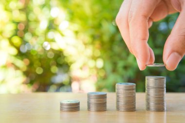 İnsan eli doğa ile büyüyen sikke yığını için para koyarak bac