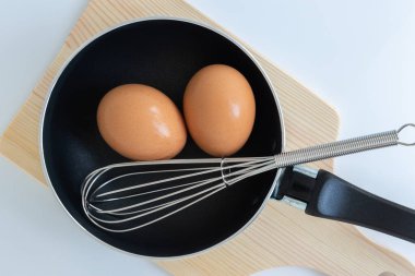 Tavayı yumurta ve paslanmaz çelikten yumurta çırpma ve beyaz arka planı doğrama ile kapat. 