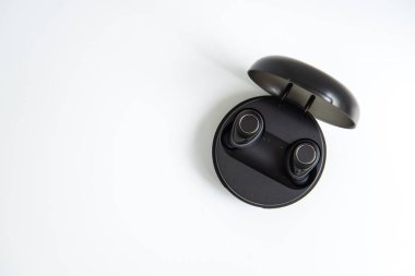 Beyaz izole arka planda güç bankası kılıfı olan siyah, gerçek kablosuz kulaklıklar.