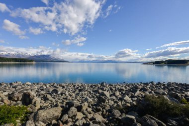Yeni Zelanda Güney Adası 'nda arka planında karlı dağlar bulunan Tekapo Gölü