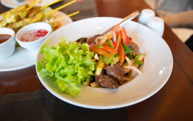 Baharatlı salata, yemek masasında et ve mezeler.