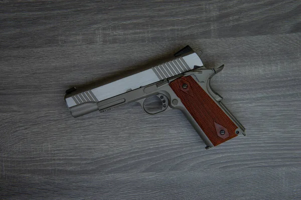 Pistola Mano Inoxidable Con Empuñadura Marrón Está Suelo Madera — Foto de Stock