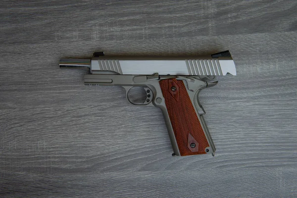 Pistola Mano Acciaio Inox Con Impugnatura Marrone Sul Pavimento Legno — Foto Stock