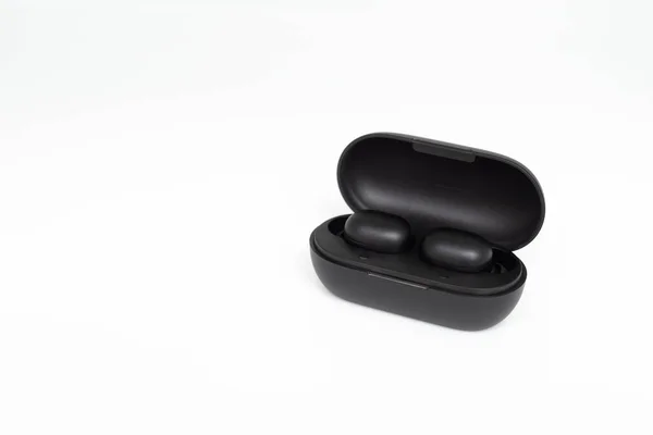 Black true wireless earbuds with power bank case on the white isolated background