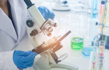 Tıbbi araştırmacılar mikroskobu kimyasal kucakta kullanıyor.