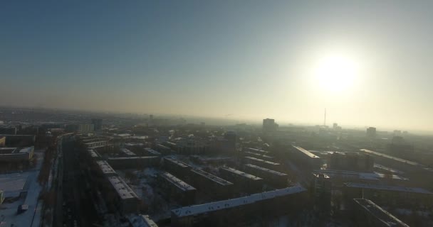 Een drone vliegt hoog over de stad in de zonsondergang — Stockvideo