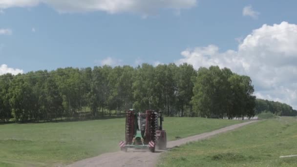 Traktor streute Dünger auf Ackerland in Waldnähe aus — Stockvideo