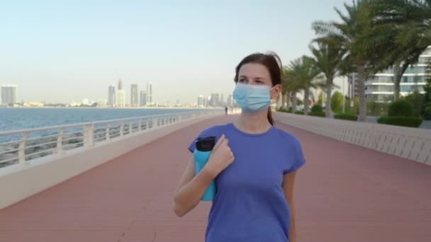 Dívka v lékařské masce na promenádě — Stock video