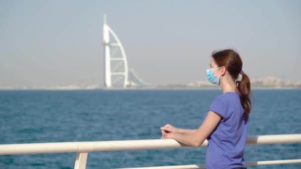 Fille dans masque médical avec vue sur la mer — Video