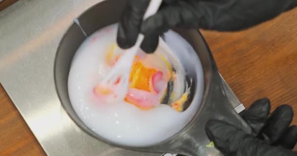 Trabalhador de salão mistura tinta capilar com solvente em recipiente — Vídeo de Stock
