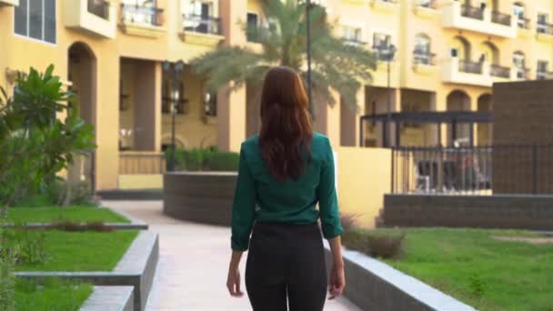 Lány megy egyenesen épületek körül — Stock videók
