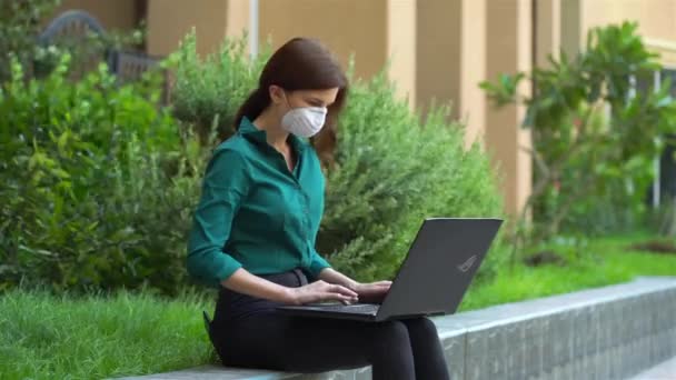 Kantoor meisje in een medisch masker met een laptop — Stockvideo