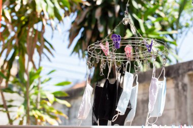 Kumaş maskeler ve hijyenik maskeler kullanımdan sonra giysi raflarına asılır. Mikropları öldürmek için güneşte yıkanır, durulanır ve kurur. Koronavirüs tekrar tekrar 2-3 kez kullanılabilir..