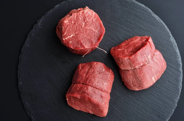 Três bifes de carne crua fresca Prime Black Angus no fundo de pedra — Fotografia de Stock